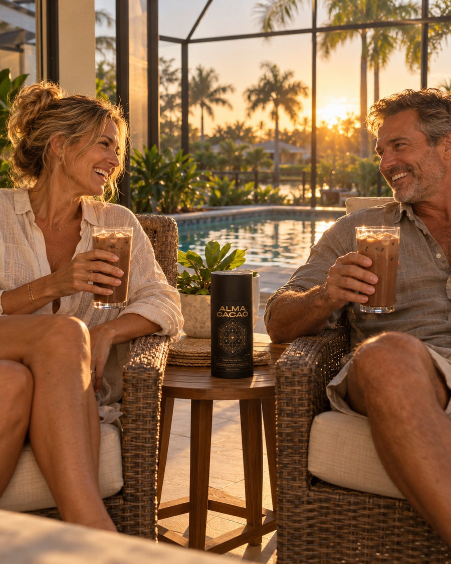 A couple laughing over glasses of iced cacao on a pool lanai in Bonita Springs, the Alma Cacao canister on the side table