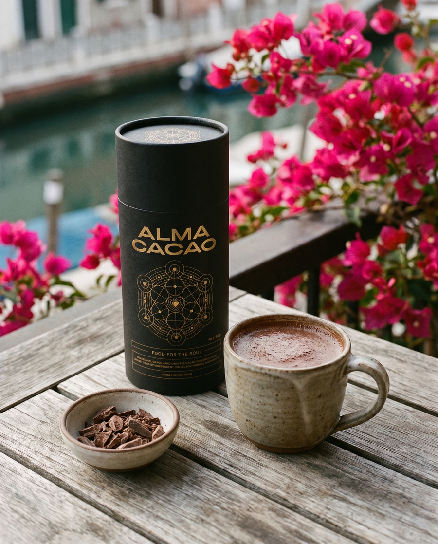 Alma Cacao canister and a mug of ceremonial cacao on a Venice balcony with bougainvillea
