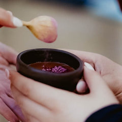 A clay cup of ceremonial cacao with a rose topping