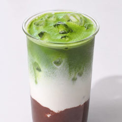 A layered iced cacao and matcha latte
