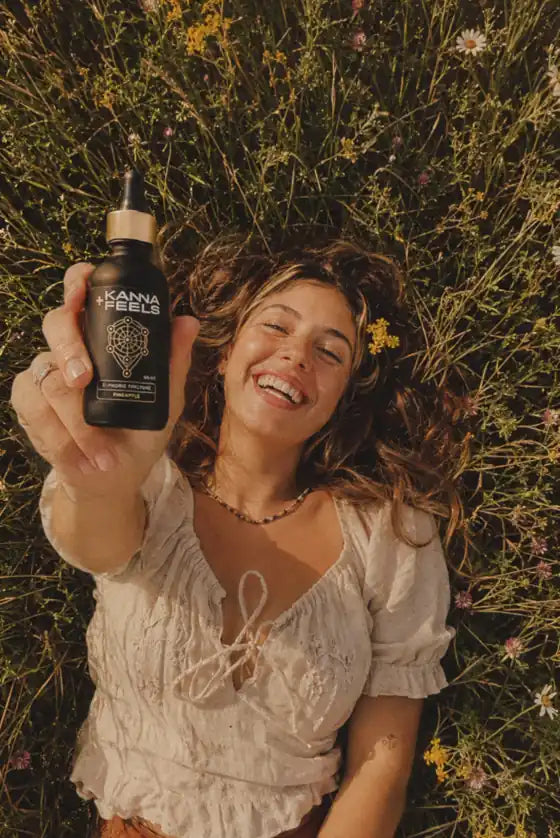 A joyful woman in a wildflower field holding Kanna Feels